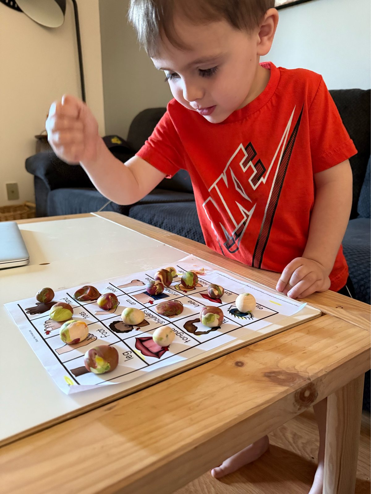 Child concentrating on a playdough body parts bingo activity