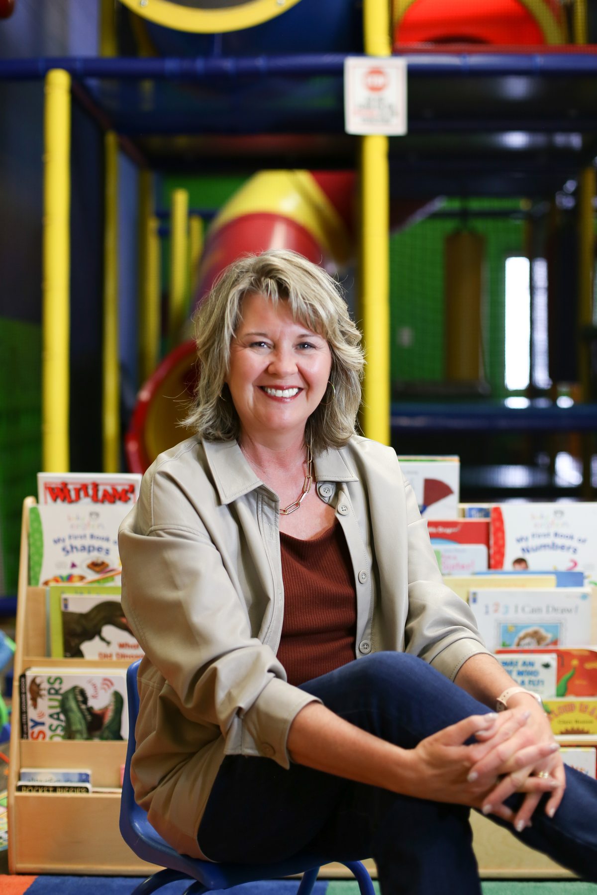 Joanne McMahon seated with children's books